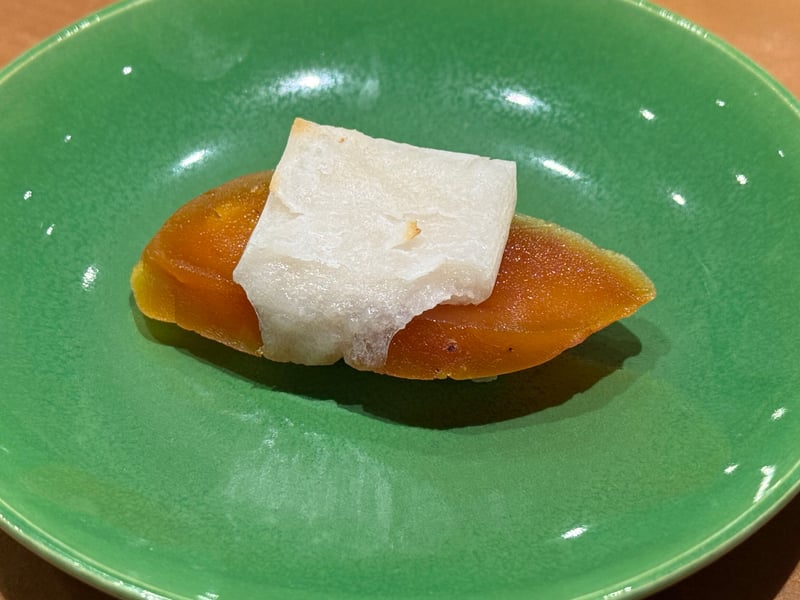 緑釉の小皿に、唐墨の薄切りと焼いた餅を重ねた一口