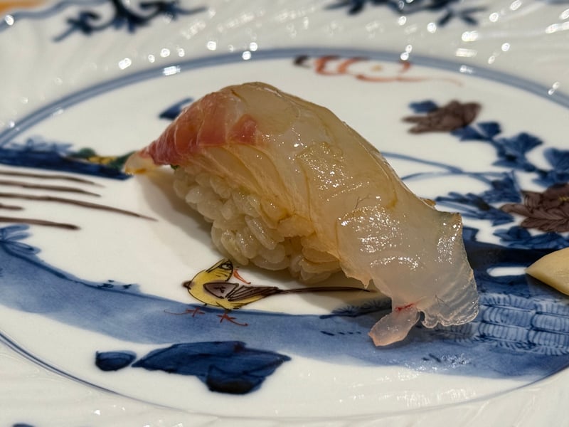 皮際の赤みが残る鯛の握り。シャリとの間に刻んだ葱がのぞく