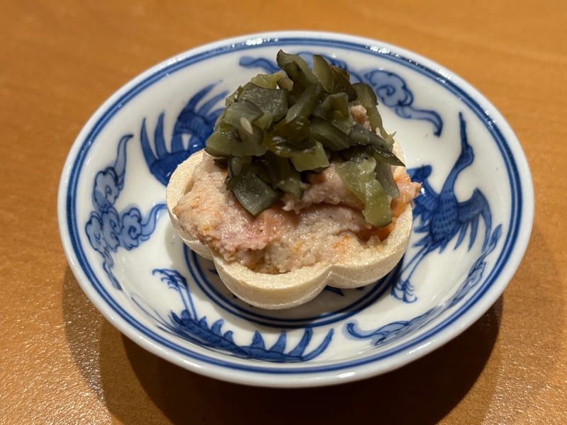 梅形の最中にあん肝のペーストを詰め、刻んだ奈良漬を乗せた一口。染付の小皿で