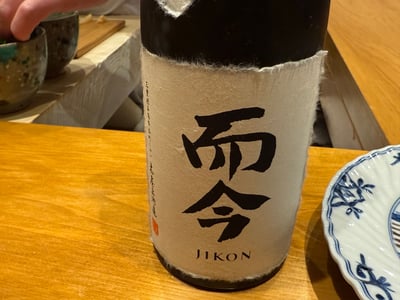 和紙を巻いた瓶に「而今」「JIKON」とある