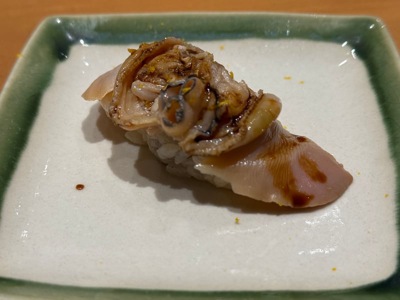 織部縁の角皿に、ツメを塗った蛤の握り。柚子の皮を散らして