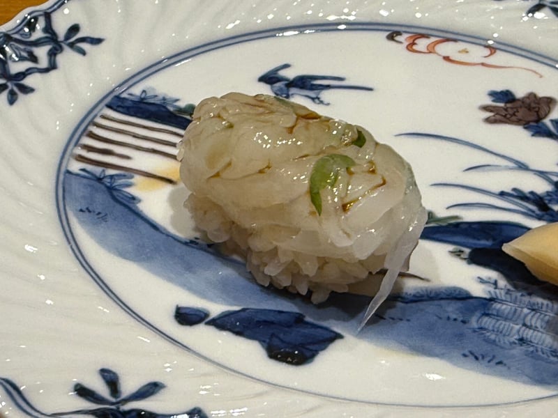 細かく包丁を入れたイカの握り。緑の刻みが混ぜ込んである