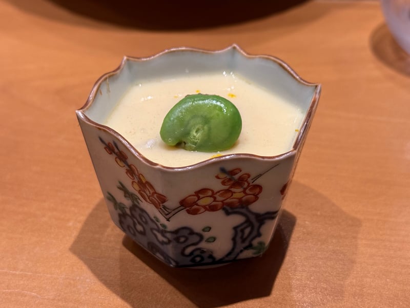 色絵の六角の器に入った茶碗蒸し。上にそら豆を一粒