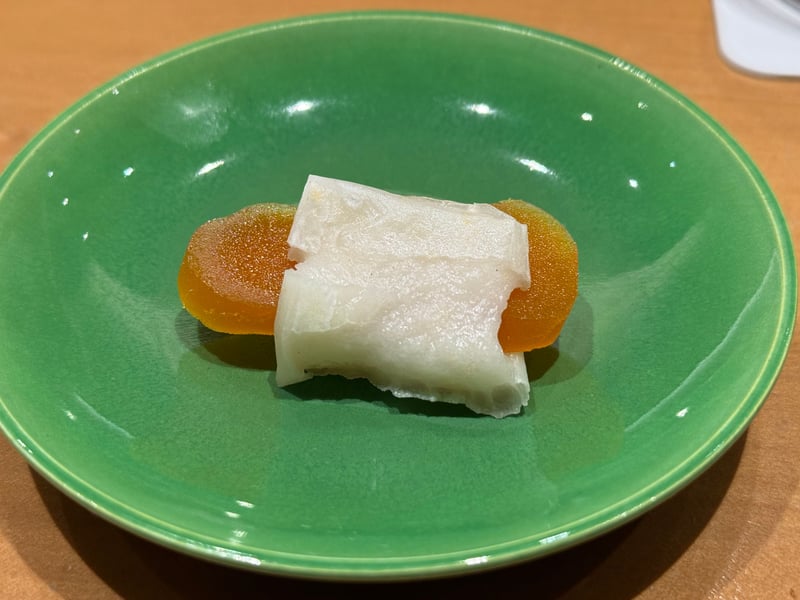 緑釉の小皿に、橙色の唐墨と白い餅を重ねた一口