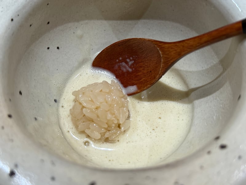 鮑を食べたあとの肝ソースに落とした小さな飯の玉と木の匙