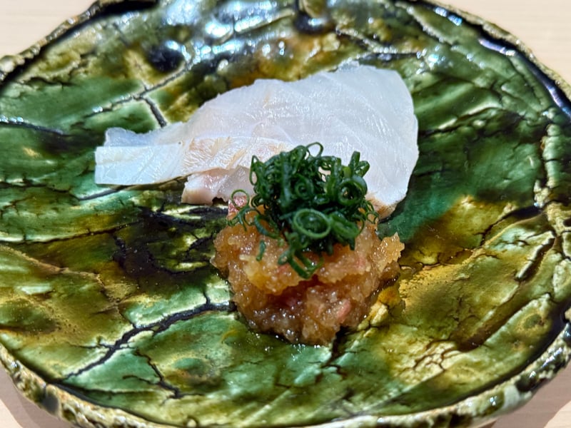緑釉の平皿に、クエの薄造りと大根おろし、刻んだ茗荷と小口葱