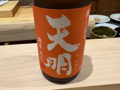 橙色のラベルの「天明 槽しぼり 純米 火入」の瓶
