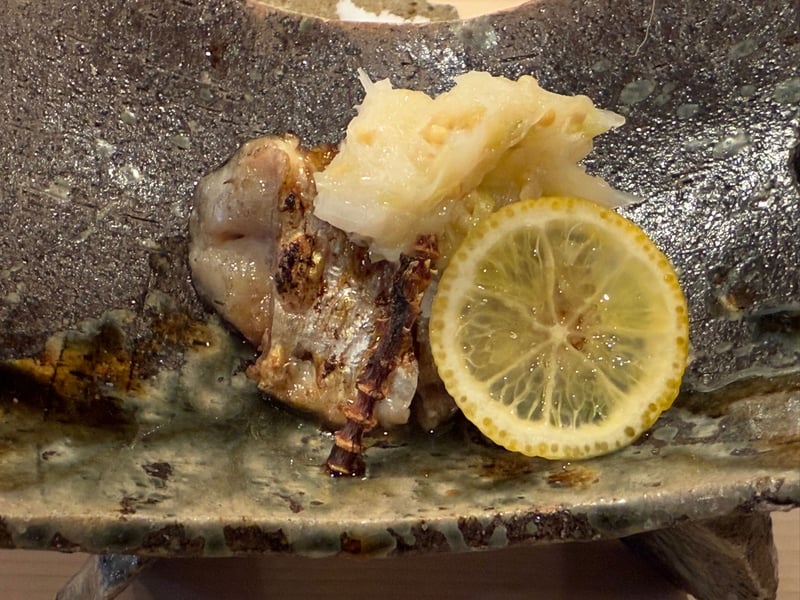 緑釉の皿に、炭火で蒸した子持ちのハタハタと大根おろし、輪切りのレモン