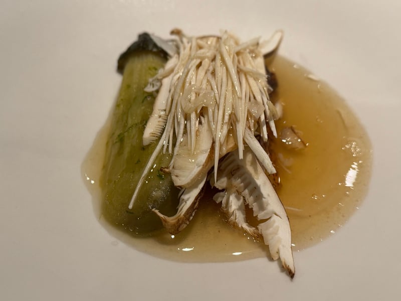 淡い出汁の皿に、青菜と、上に千切りの生の松茸