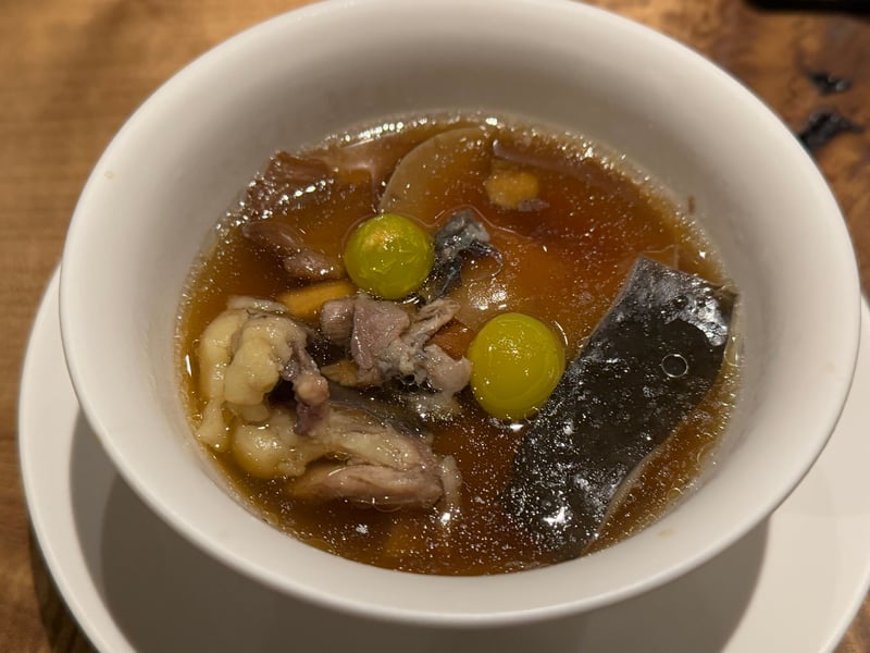 白い椀に、すっぽんときのこ、銀杏を浮かべた琥珀色のスープ