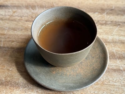 粉引の碗と受け皿に注がれた褐色のお茶