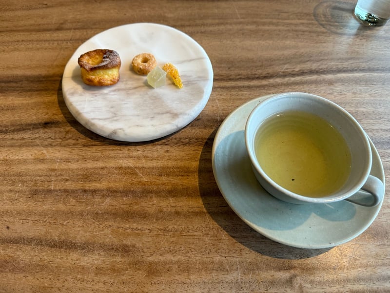 大理石の皿にのった小菓子四種と、緑茶のカップ