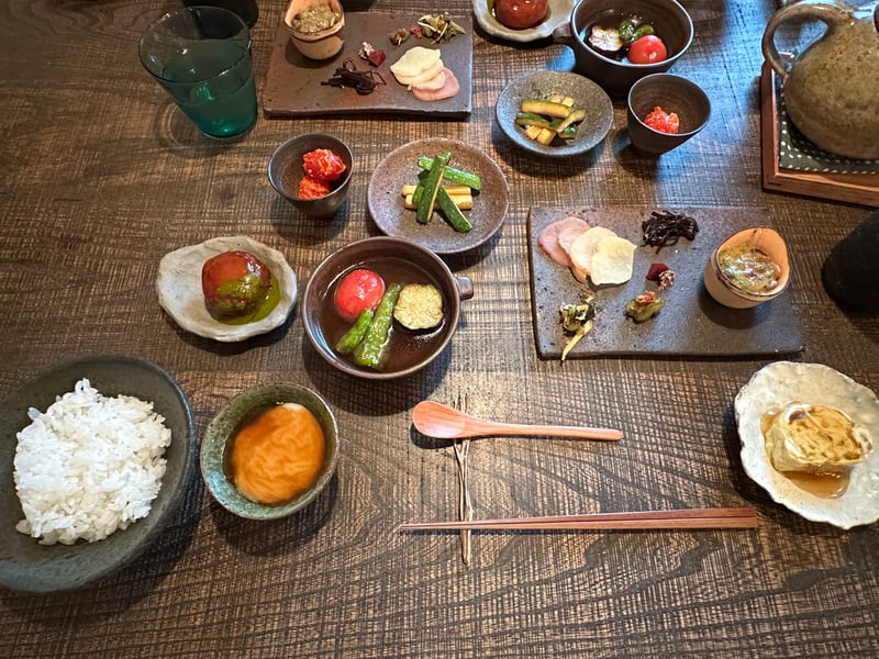 朝食のご飯のお供が並ぶ膳。ジーマミー豆腐、熟成明太トマト、ズッキーニのきんぴら、オクラ納豆、卵焼き、かぼちゃ団子