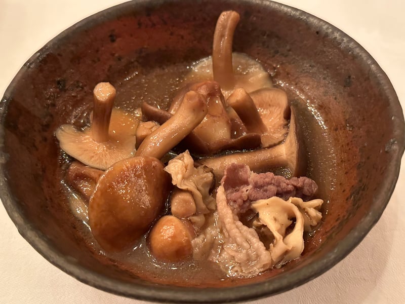 褐色の鉢に、きのことツキノワグマのしゃぶしゃぶ