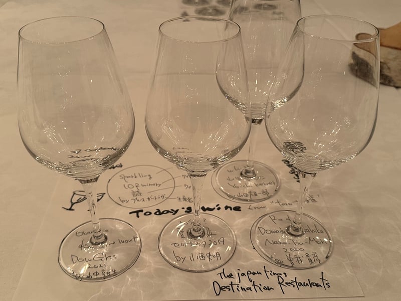 手書きの「Today's wine from team 余市」のカードと、6脚のグラス