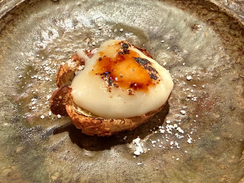 皿にプルーンのシュークリーム。焼いた生地の上に、表面に焼き色をつけたクリーム