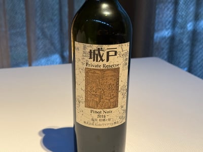 白いテーブルに立つ城戸 Private Reserve Pinot Noir 2018 のボトル