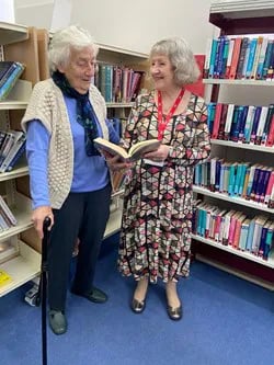 Lady volunteer helping eldly woman with a cane