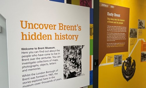 Welcome board at Brent Musuem's entrance. Its tile is Uncover Brent's Hidden History, then a paragraph and a black and white. Then, a few lines about Early Brent on a brown board on a yellow background.