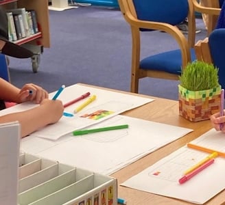 child drawing on paper with felt tips
  