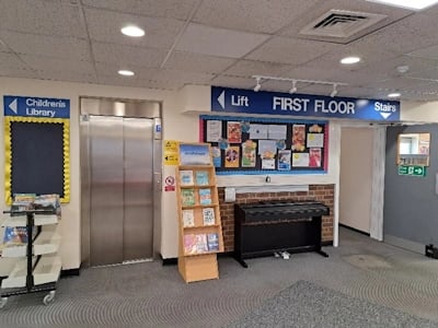 lift, book shelves and 'First Floor' sign in library