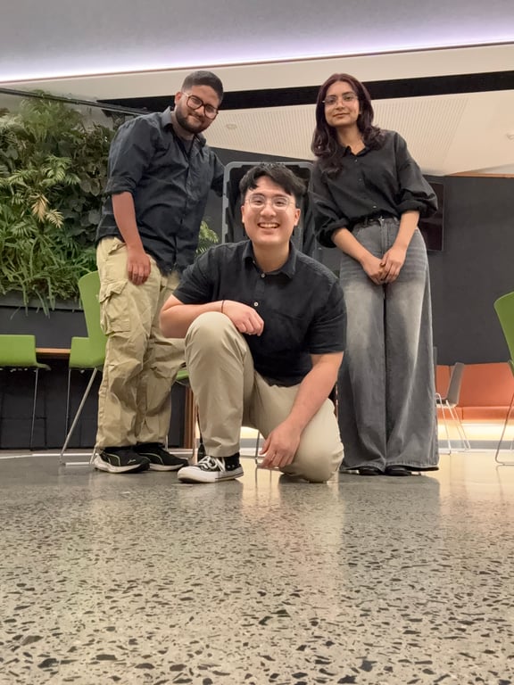 Team portrait in a bright workspace with a living wall behind