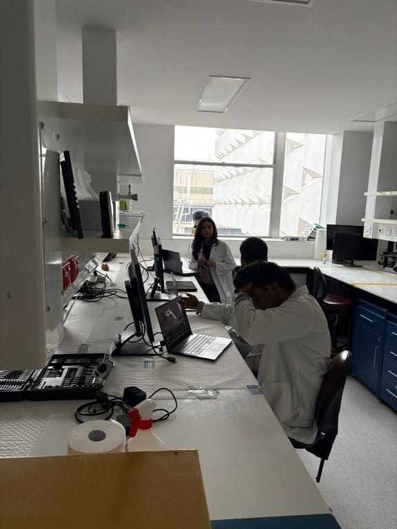 Three teammates in white coats working on computers