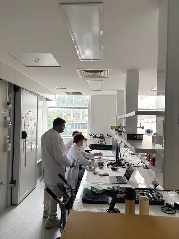 Three teammates in white coats working on computers