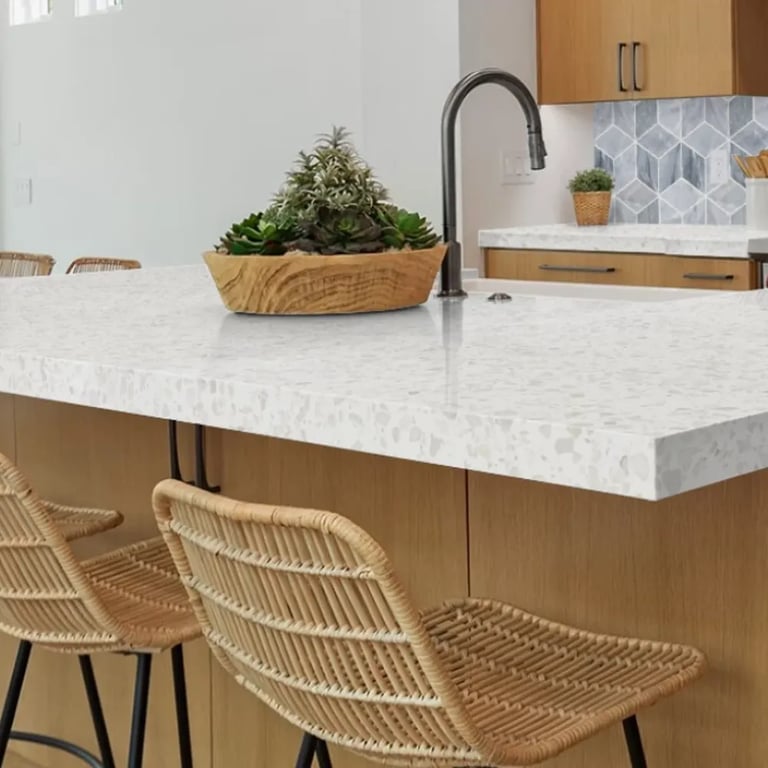 Iceberg agglomerate marble on counters), CS-Deep Blue Honed Rhomboid marble on backsplash & Bio Attitude Cotton 8 x 48 wood-look porcelain tile on floor in kitchen.