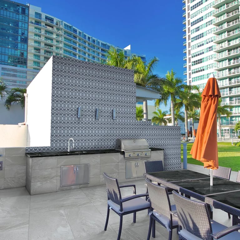 Negresco Satin (counter/tables), Fluida Nebula 12 x 24 (bbq surround), Fluida Nebula 24 x 48 Active R11 Finish (patio) & Curve Blue 8 x 8 (wall)