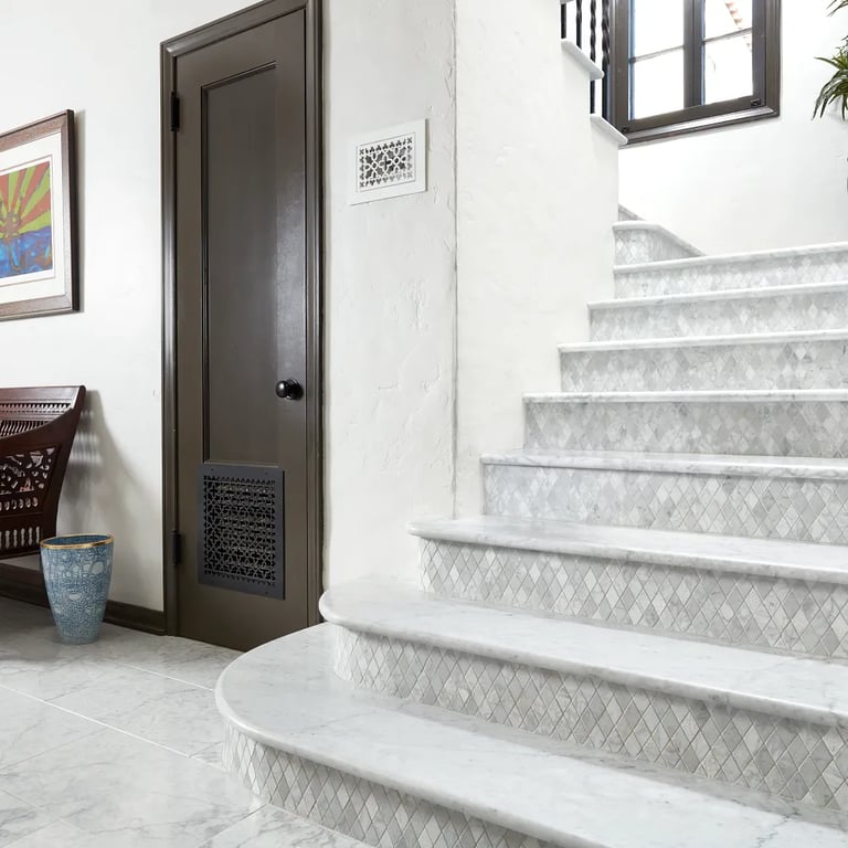 Bianco Carrara Honed Slab marble on stair treads, Bianco Carrara Custom Mosaic marble stair risers & Bianco Carrara Honed 12 x 24 marble floor in entryway.