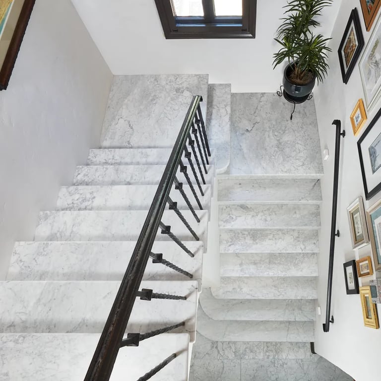 Bianco Carrara Honed Marble Slab on treads and landings in stairwell as well as Bianco Carrara Honed 12 x 24 marble tile on floor.
