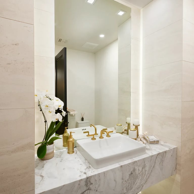 Calacatta Umber Polished marble countertop & Tivoli Beige 18 x 36 porcelain tile on walls in bathroom.