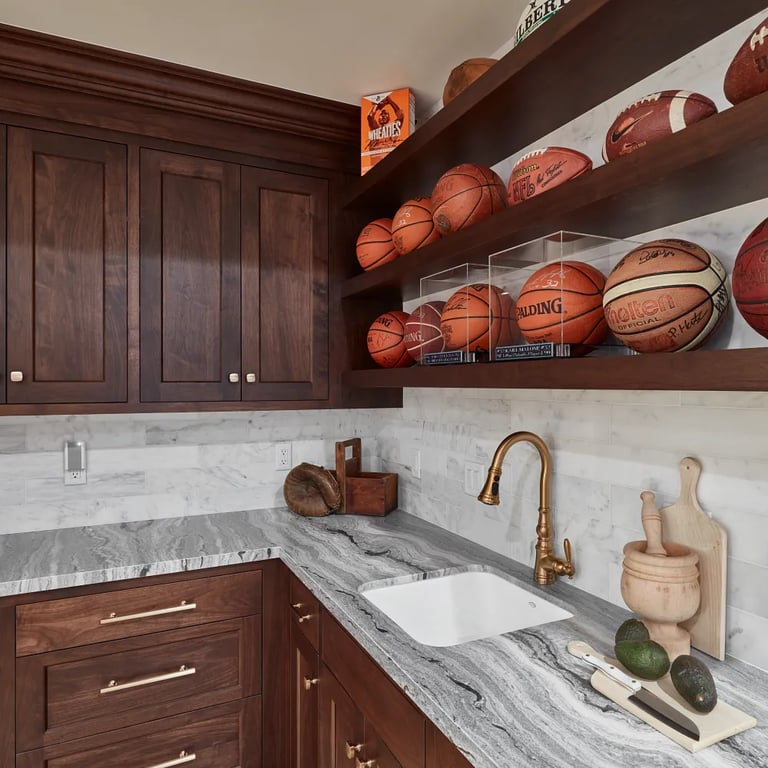 Fantasy Ocean Satin marble on countertop & Calacatta Gold Honed 4 x 16 marble on backsplash on wet bar in luxury game room.