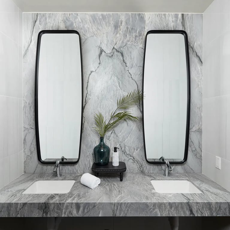 Blue Tahoe Satin quartzite on vanity & backsplash, Themar Bianco Lasa Polished 24 x 24 porcelain tile on left and right wall, and Ardesia Black 24 x 48 porcelain tile trim on left wall in bathroom.