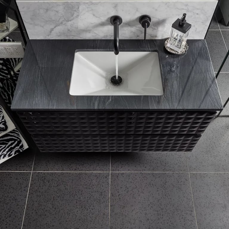 Brilliant Black Quartzite on countertop, Bianco Carrara Polished Marble 24 x 48 on backsplash & Terrazzo Black 24 x 24 Porcelain tile on floor in bathroom.