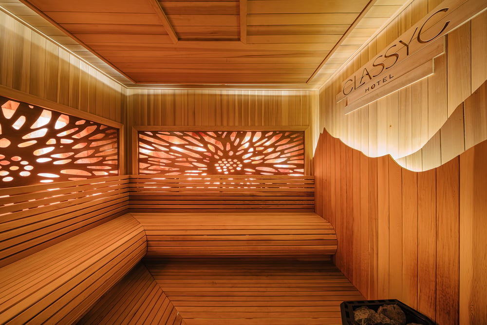 The sauna with its backlit carved panel and wooden benches