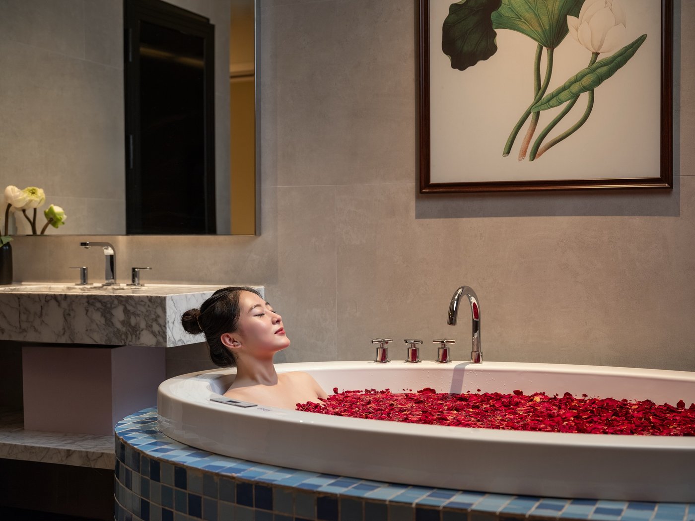 Guest resting in a Jacuzzi tub with rose petals