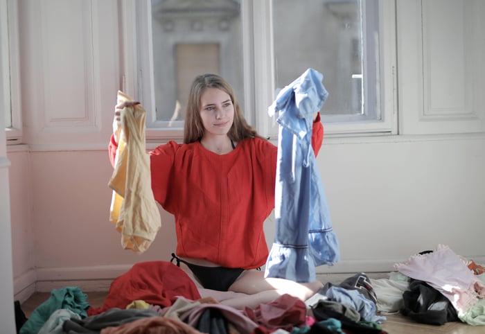 a woman deciding between clothes
