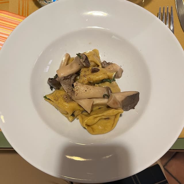 Foto do prato “Ravioli alla curcuma ripieni di patate e zucca con funghi e salvia”