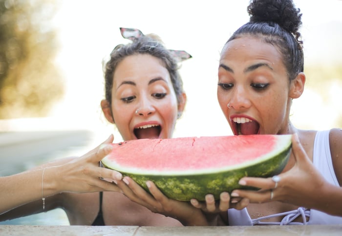 Two women eating watermelon