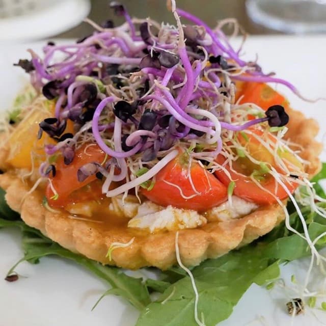 Foto do prato “Crostatina Di Pomodori, Ricotta Di Anacardi, Limone E Germogli”
