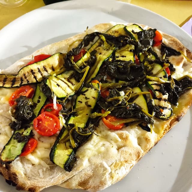 Photo of the dish “Pinsa "Totò" pomodorini marinato, friarielli, zucchine gialle, parmaveg.”