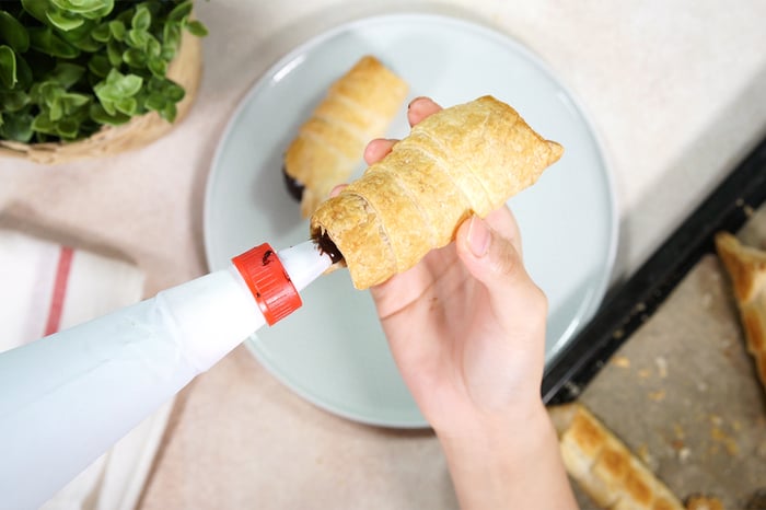 pipping chocolate into cannoli