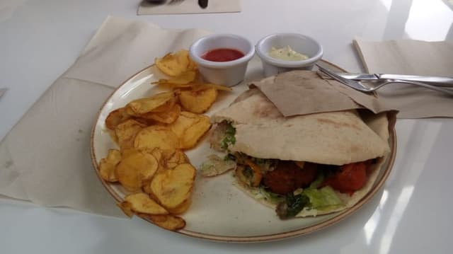 Photo du plat “Pita de vegetales y falafel con chips de papá criolla y jugo de mango”