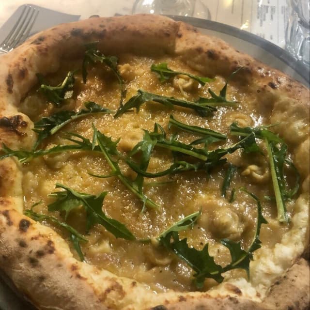 菜肴“Pizza con crema di cipolla, ceci fritti e cicoria cruda”的照片