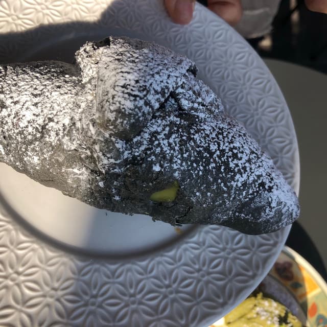 菜肴“Cornetto Con Impasto Al Carbone Ripieno Al Pistacchio”的照片