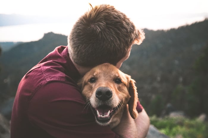 man hugging his dog