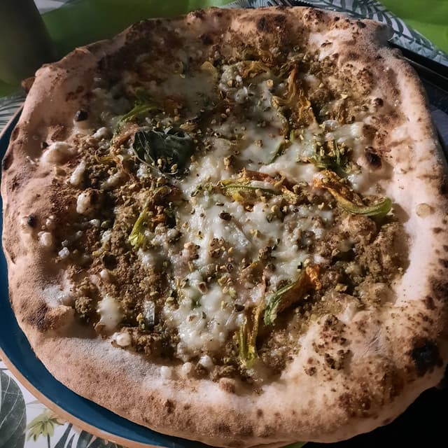 菜肴“Pizza Cocorita vegan (pistacchio, fiori di zucca e formaggio vegan)”的照片