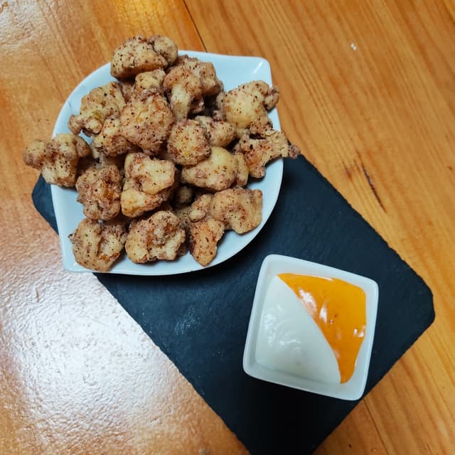 菜肴“Palomitas de coliflor con especias toragashi y salsa brava”的照片